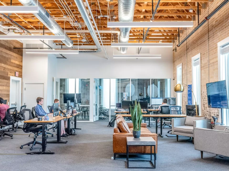 Open-plan office with people working at desks and screens