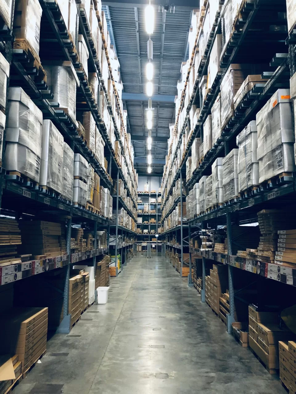Tall warehouse shelving stacked with boxes and pallets