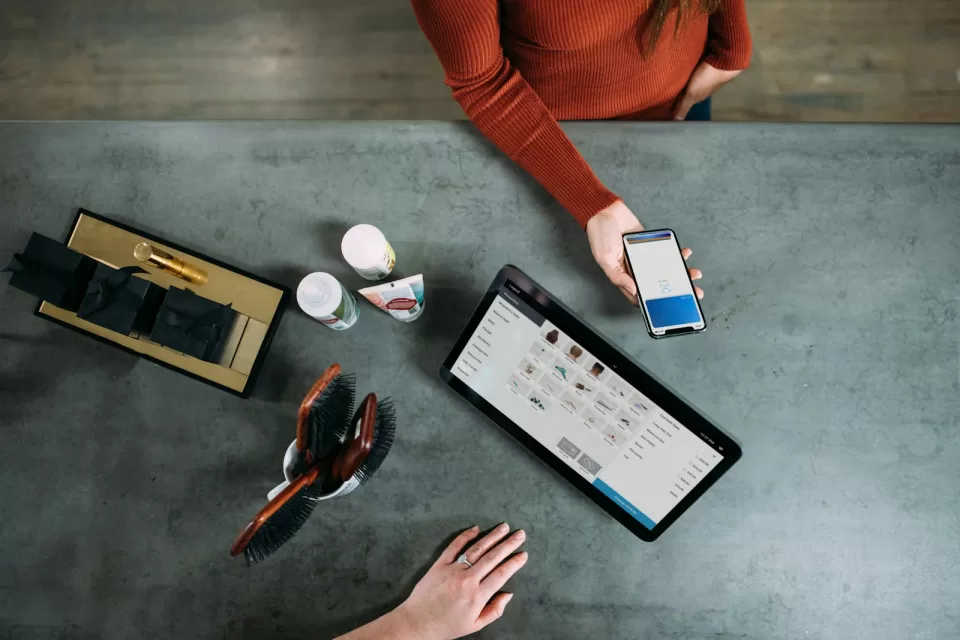 Person paying with a smartphone at a café table