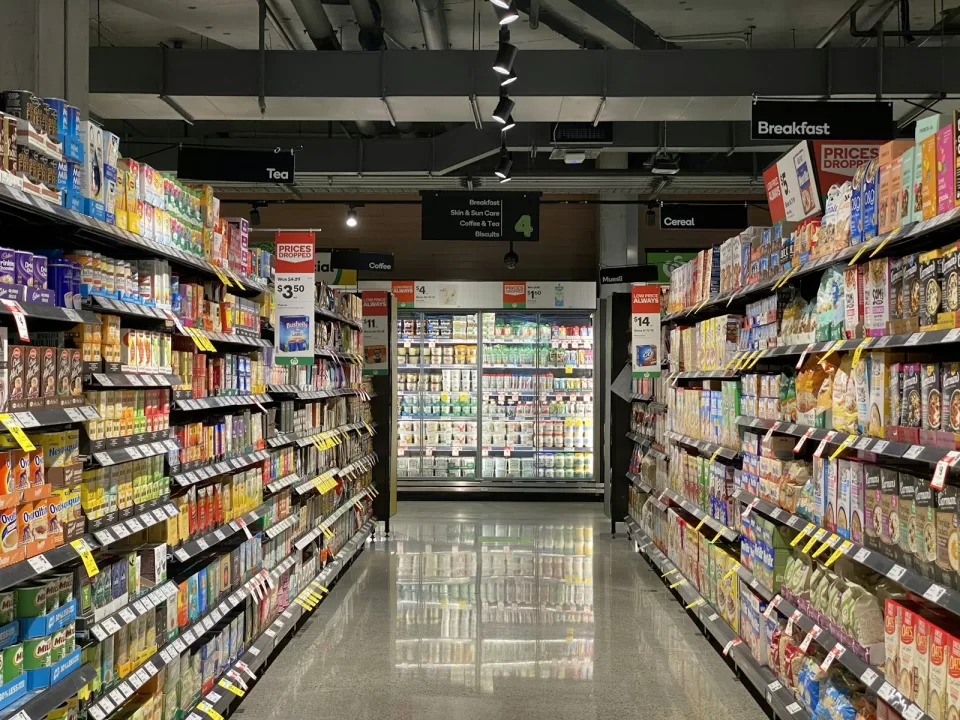 Long supermarket aisle with neatly stocked shelves on both sides