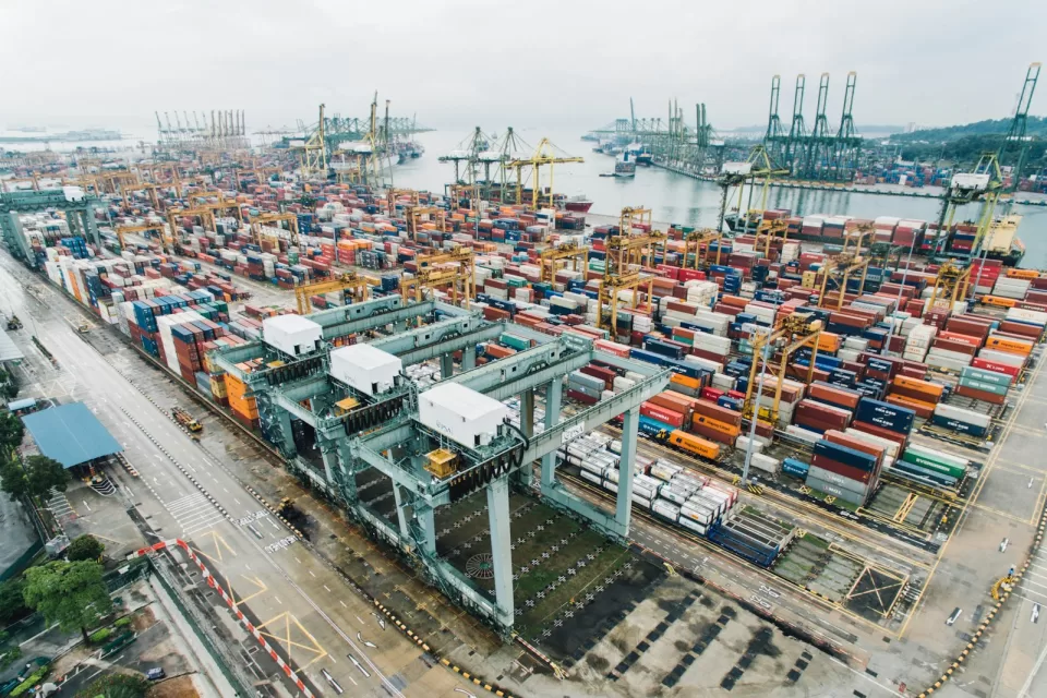 Aerial view of a busy container port with cranes and stacked containers