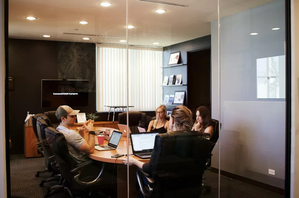 Conference room with a long table, chairs and a large screen