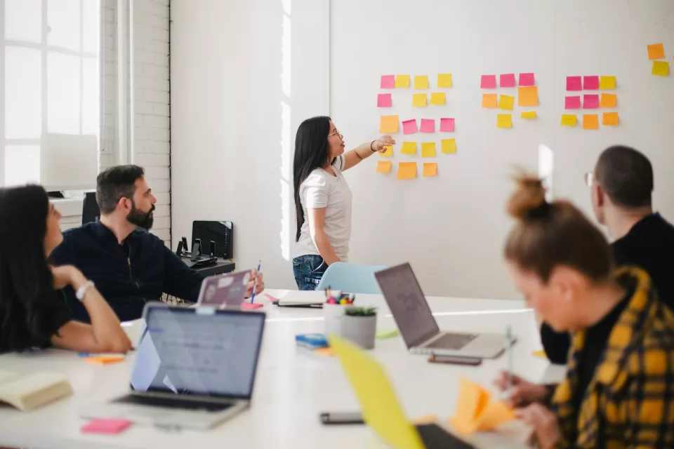 Team discussing a project around a table covered with sticky notes