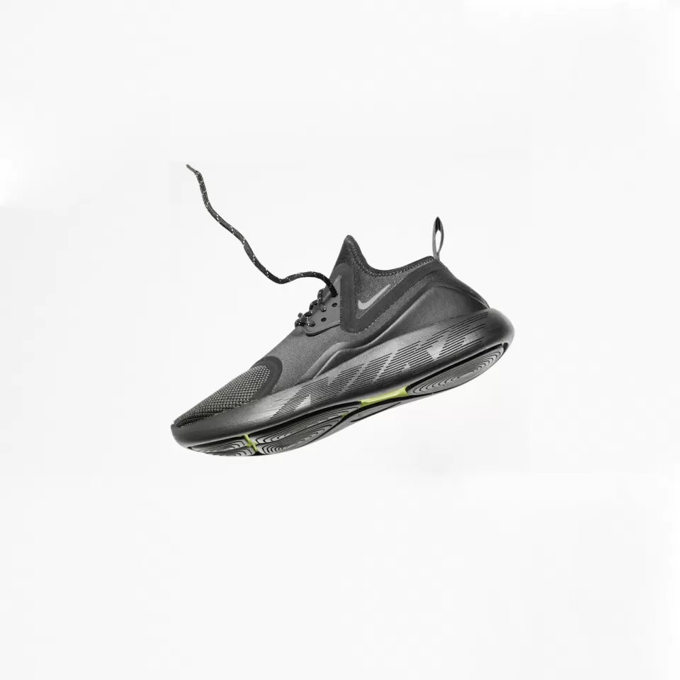 Black running shoe photographed floating against a white background