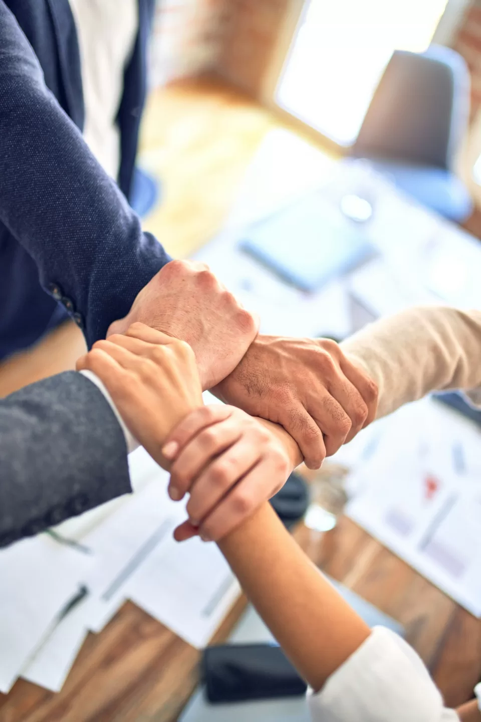 Several people placing their hands together in a team gesture