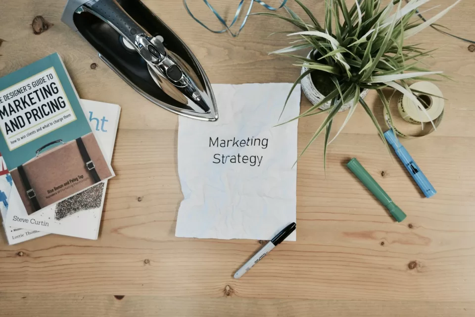 Desk with a laptop, notebook and marketing strategy notes