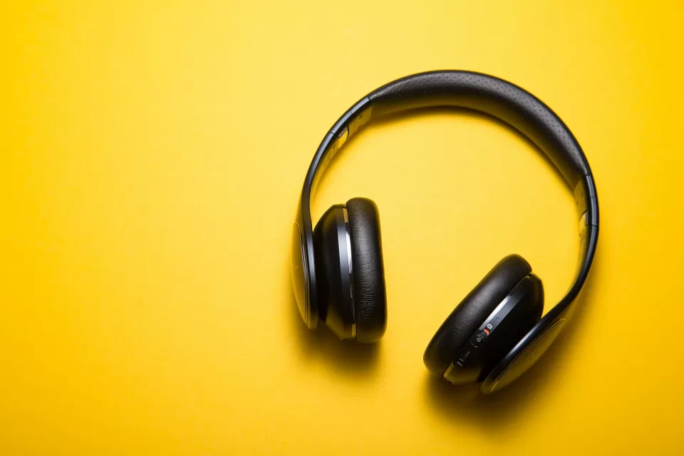 Pair of headphones photographed against a bright yellow background