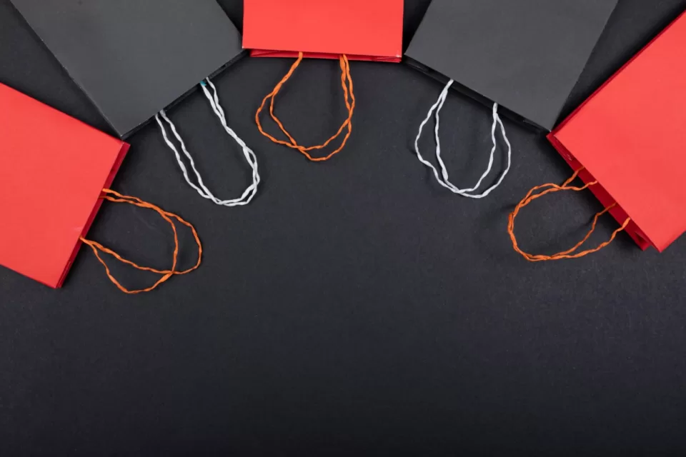 Red and black shopping bags arranged on a red background