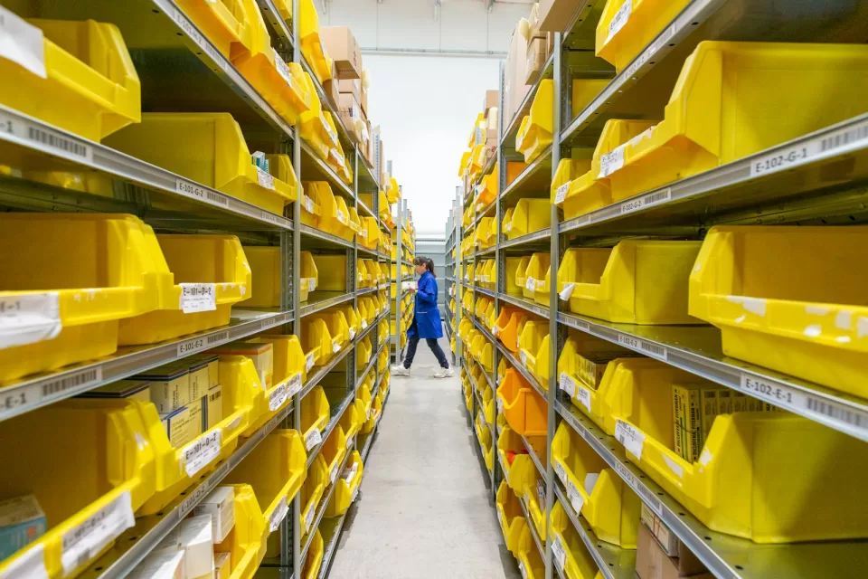 Rows of yellow storage bins on warehouse shelving