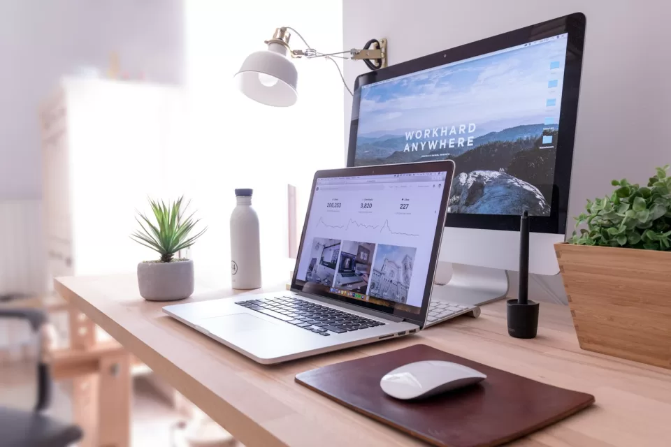 Desk with two computer monitors and a keyboard in a bright office