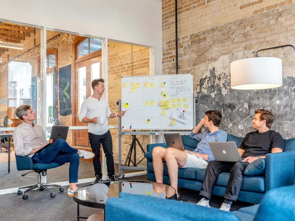 Team working together at a whiteboard covered in notes