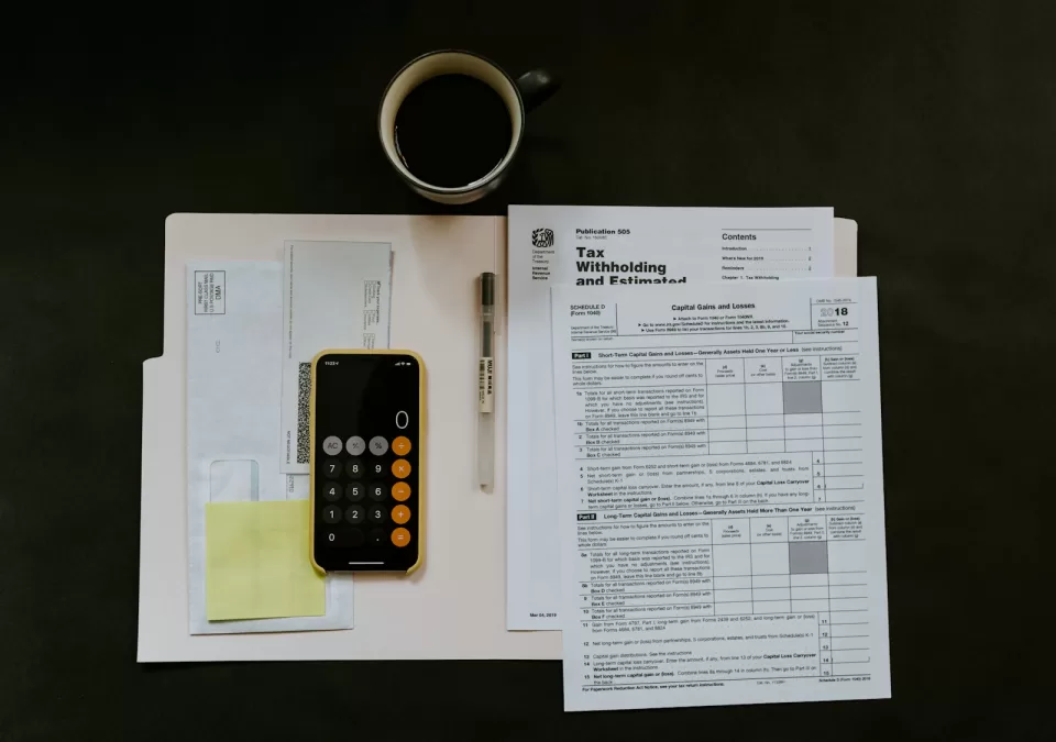 Calculator, pen and financial documents on a desk