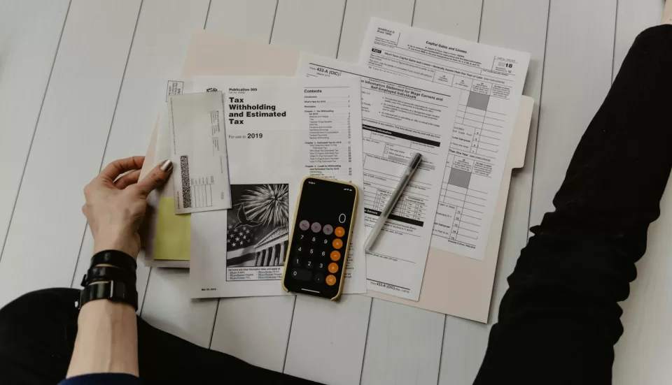 Financial documents and forms on a desk with a pen