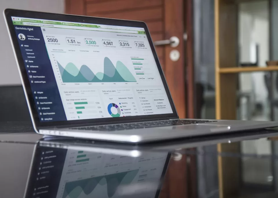 Laptop on a desk showing charts and analytics on its screen