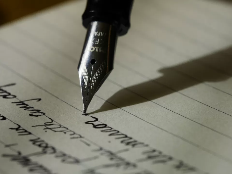 Close-up of a fountain pen writing on lined paper
