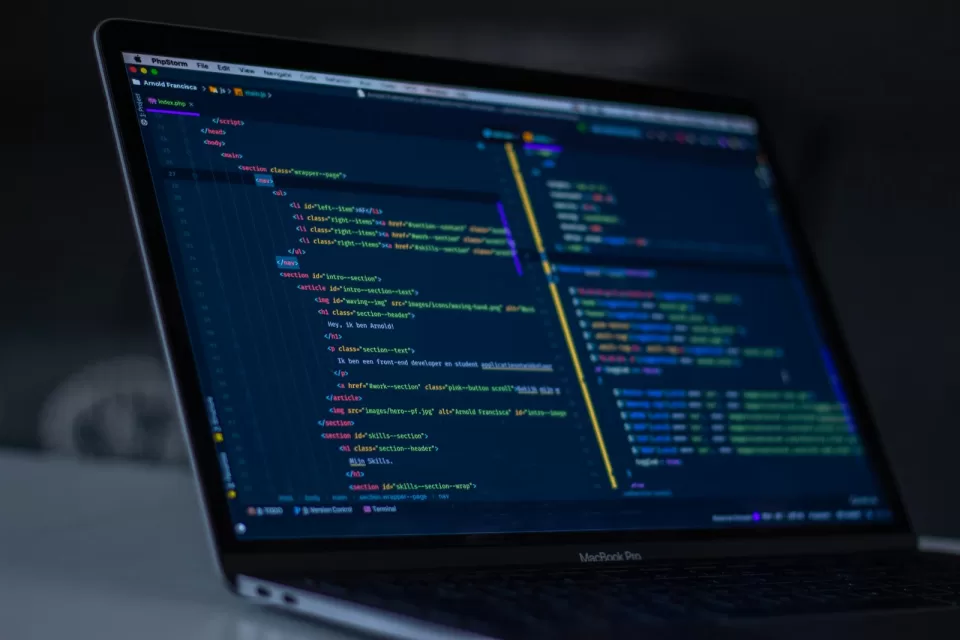 Laptop screen showing colourful code in a dark editor