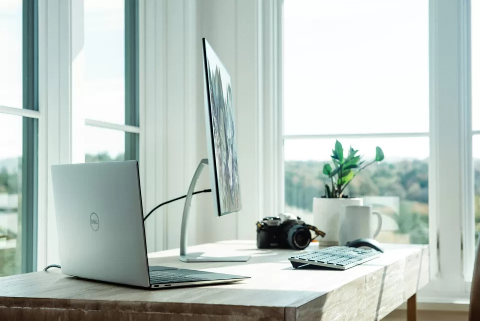 Laptop on a tidy desk beside a bright window