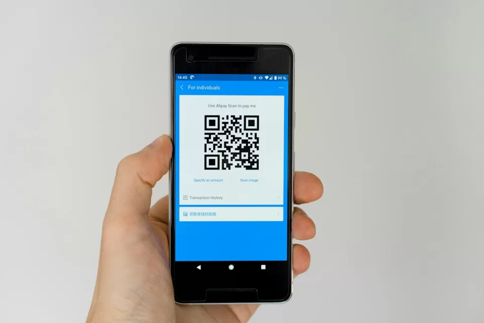 Smartphone showing a QR code in a person's hand