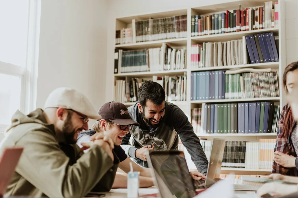 Students looking at a laptop together in a library