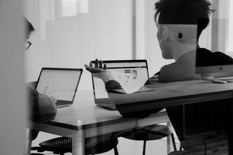 Developers working on laptops in a bright office